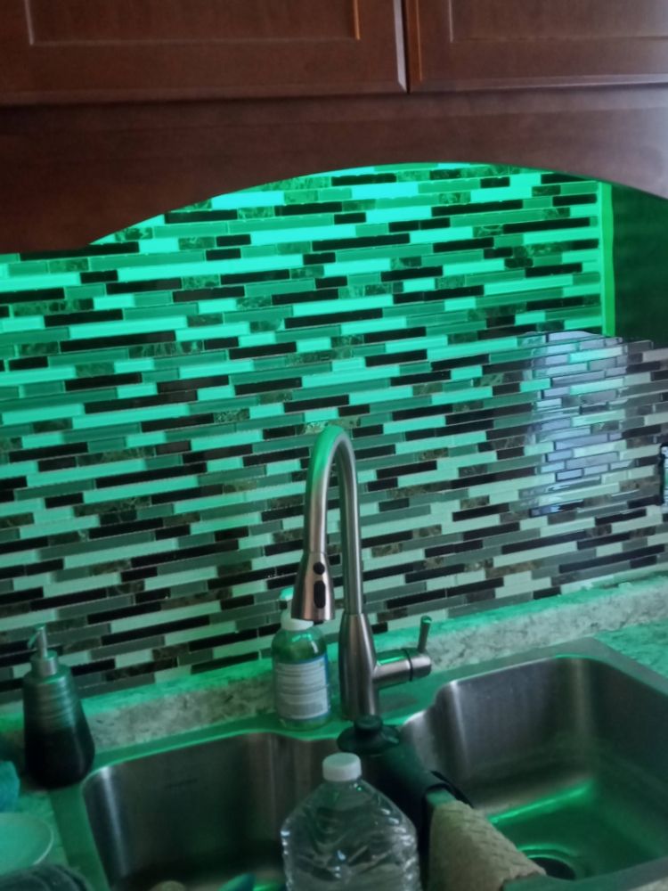 Glass tile backsplash with green LED accent lighting